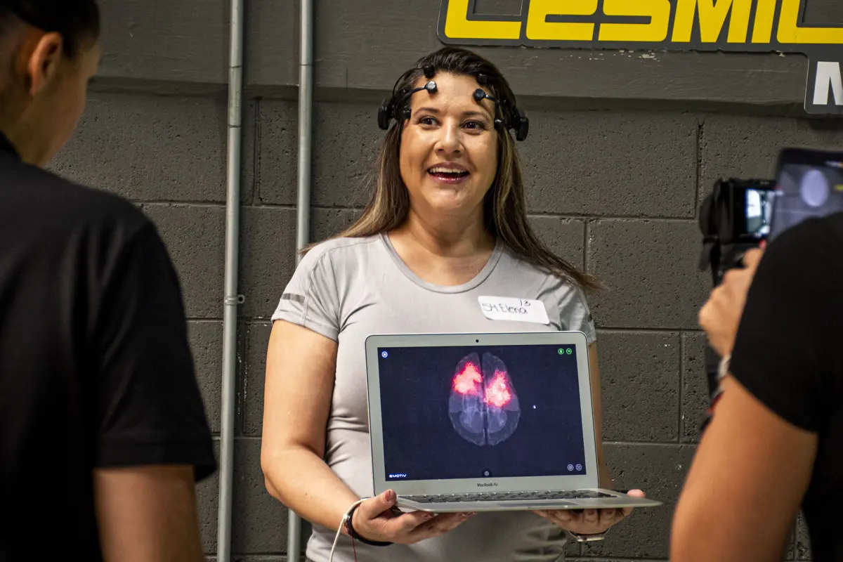 Participante sonriendo con su lectura EEG en pantalla